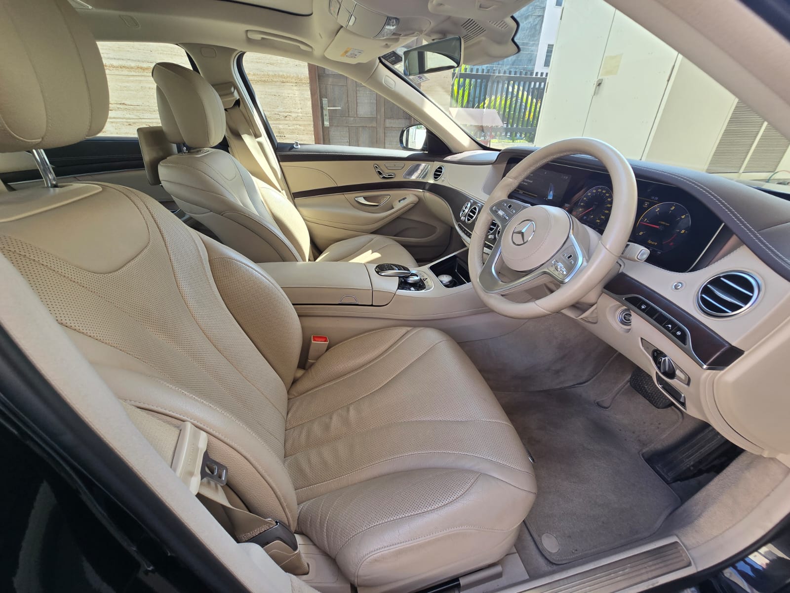 Driver door open showing cream leather seats and dashboard